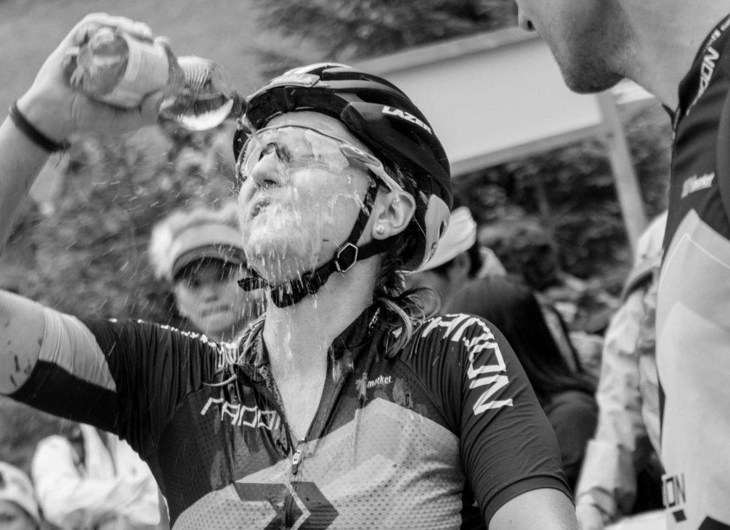 Sportfotografie-München-Mountainbike-MTB-Frau-Wettkampf-Erfrischung-Wasser im Gesicht-schwarz-weiss