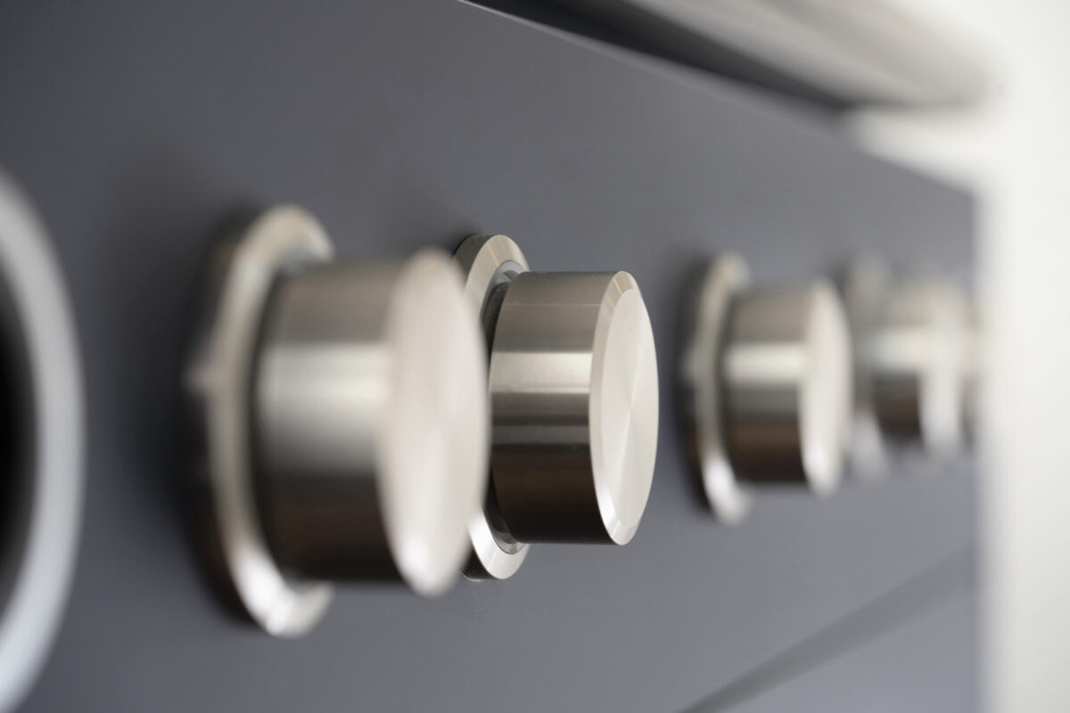 Detailaufnahme von Metall-Drehreglern eines Berbel Kochfelds mit geringer Schärfentiefe. Interieur- und Küchenfotografie von Fotograf Robert Niedring in München